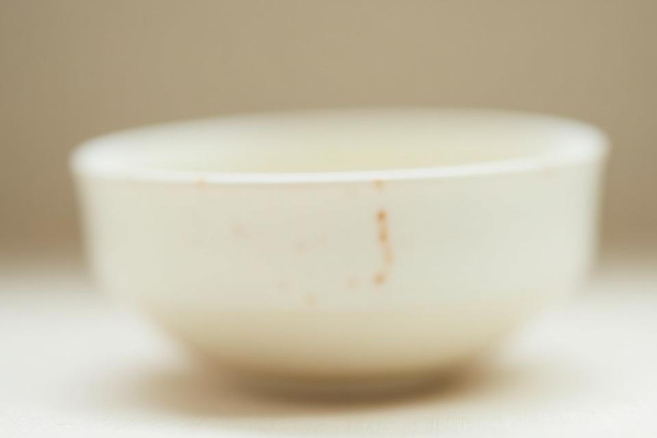 温かみのある乳白色の志野焼の器に小さな貫入と火色が見える